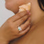 Person holding a shell to their neck with a blurred background