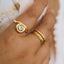 Hand wearing two gold rings with a blurred background