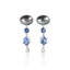 A pair of silver drop earrings featuring a large oval black pearl, a small round blue gemstone, a larger teardrop-shaped blue gemstone, and a small clear teardrop pearl at the bottom, set against a plain white background with a soft reflection.